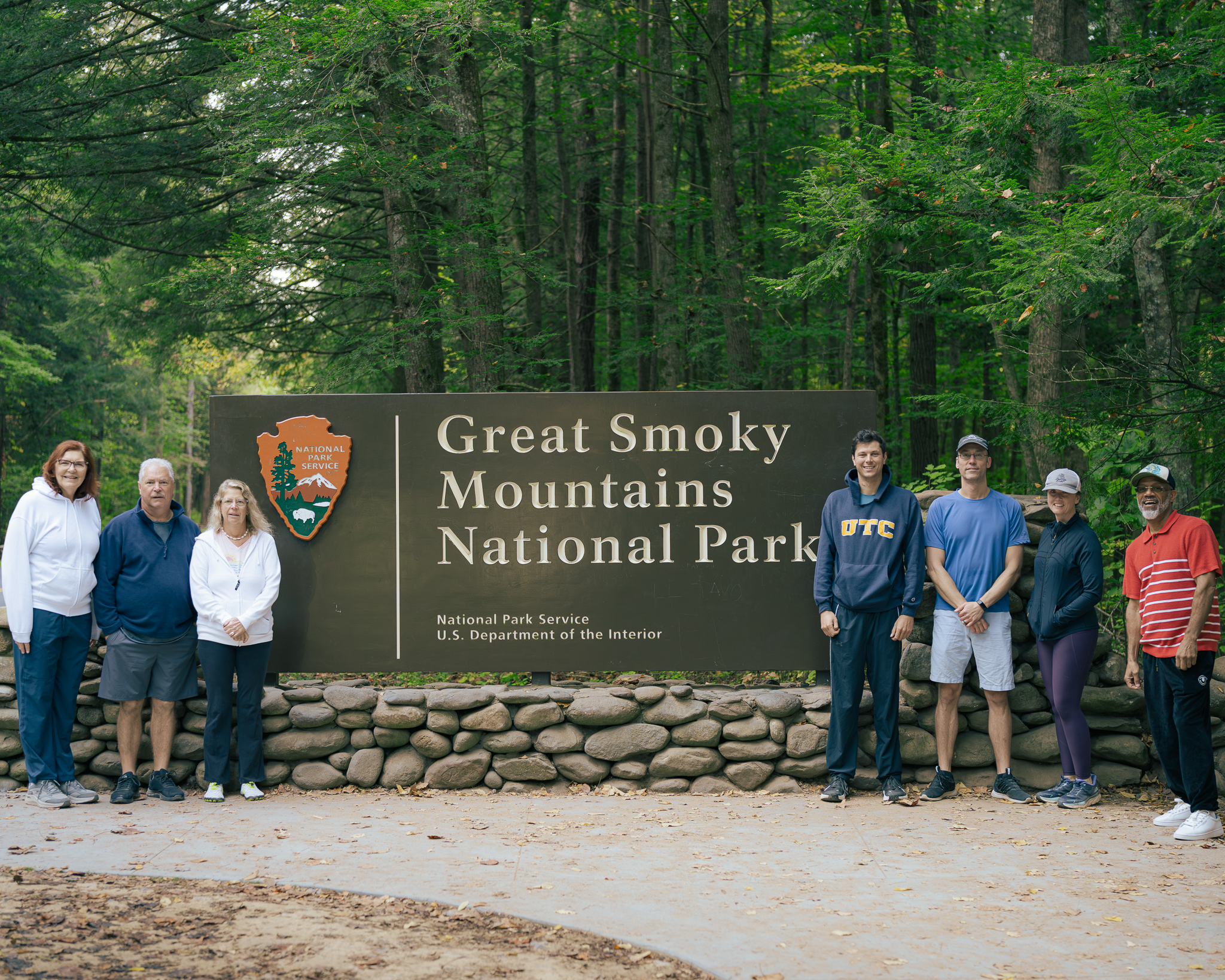 The Last Life Ever group standing together at the Great Smoky Mountains National Park sign